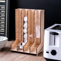 a toaster sitting on top of a wooden table next to a box filled with white balls