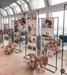 a room filled with pictures and flowers on the floor in front of large glass windows