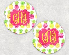 two pineapple coasters with the initial monogrammed in yellow, pink and green