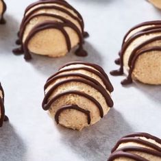 several cookies with chocolate drizzled on them sitting on top of a table