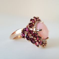 Peruvian Pink, Opal. Orissa, Rhodolite Garnet. White Zircon. Ring. Size (6). Vermeil Rose Gold Over Sterling Silver. Peruvian Pink Opal. Oval. (119) Mm. Height (23) Width (24) Mm. Orissa Rhodolite Garnet. Rounds And Marquise Cut. (26) Ct. Zircon Rounds (22) Ct. Prong Set. Beautiful Peruvian Pink Opal, Surrounded With Halo Of Orissa Rhodolite Garnet. Gorgeous Blend Of Gemstones And Color's. Pastel Pink's. Purplish Pink's, Rosey Reds. Wine. Chardonnay. White Shimmering Zircons. Boutique. Celestial Rhodolite Ring, Pink Opal Ring, Rhodolite Garnet Ring, Gold Tassel Necklace, Colored Stone Rings, Daisy Necklace, Beaded Tassel Earrings, Gold Rings Fashion, Daisy Earrings