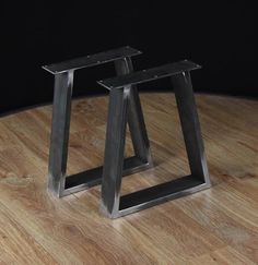 two metal tables sitting on top of a wooden floor