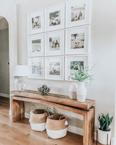 a wooden bench sitting in front of a wall with pictures on it