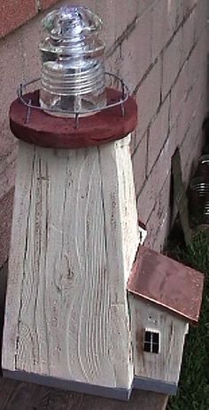 a birdhouse made out of wood with a glass dome on top and a metal roof