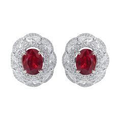 18 Karat White Gold 3.72 Carat Ruby and Diamond Cluster Stud Earrings This regal pigeon blood ruby oval earring sets the tone for something special. The insensuous blood ruby pair is surrounded by a simple cluster of pave set diamonds and then by the inclusion of solitaire marquise diamonds clustered with an umbrella layer of small pave diamonds add more depth and detail to this formidable classy stud earring pair. Details of the piece: Gross Weight: 9.392 grams 18 Karat Gold: 8.294 grams Ruby: Luxury Red Brilliant Cut Earrings, Red Cluster Earrings For Formal Events, Luxury Ruby Earrings With Halo Design, Ruby Flower, Blood Ruby, Semiprecious Stone Jewelry, Oval Earrings, Earring Sets, Red Jewelry