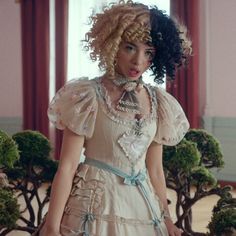 a woman with curly hair wearing a dress