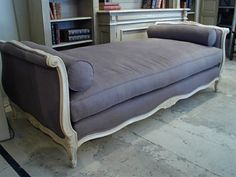 a couch sitting in front of a book shelf