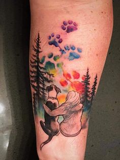 a tattoo on the leg of a person with a dog and trees in the background