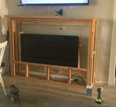 a flat screen tv sitting on top of a wooden entertainment center in a living room