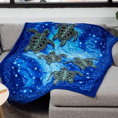 two sea turtles swimming in the ocean on a blue blanket