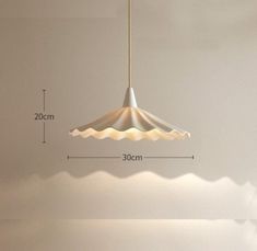 a white lamp hanging from a ceiling in a room with measurements for the light fixture