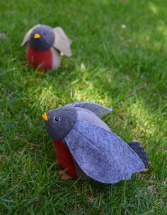 two felt birds sitting in the grass