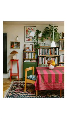 a dining room with a table, chairs and bookshelf filled with lots of books