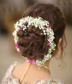 a woman with flowers in her hair is wearing a flowered headpiece and looking off to the side