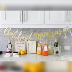 a kitchen counter topped with lots of bottles and glasses next to a sign that reads, but first mymossaas