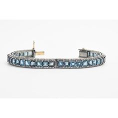 Pair of London blue topaz and diamond bangles mounted in sterling silver with a 14k gold tongue clasp and safety. Each bracelet contains princess cut blue topaz prong set down the center with round diamonds along the side edges.  The 2 bracelets have a combined carat weight of 5.28 carats in diamonds and 61.23 in London blue topaz.  Internal circumference is 7.12".  across inside 2 3/8" by 2 5/16" Elegant Blue Topaz Bracelet, Blue Topaz Gemstone Bangle Jewelry, Fine Jewelry Blue Topaz Bracelets, Sterling Silver Gemstone Bracelet, Elegant Formal Topaz Bracelets, Elegant Formal Topaz Bracelet, Classic Topaz Jewelry With Gemstone Accents, Timeless Blue Jewelry With Single Cut Diamonds, Elegant White Gold Bracelet With Blue Topaz