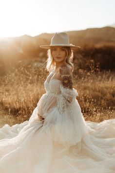 a woman in a white dress and cowboy hat