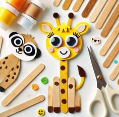 a giraffe cut out from popsicle sticks, scissors and other crafting supplies