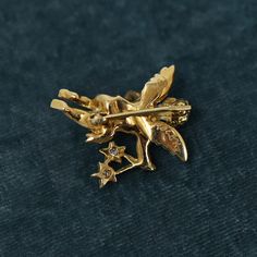 exquisitely detailed 3-dimensional cherub adorned in a diamond sash and holding two diamond stars. This beautiful piece would also work well as a pendant, permanently converting for use as a necklace, or remaining intact for the option of styling as a brooch  materials: 18k, 7.07 grams, approximately 0.15ctw all VS, 9 diamonds approximately 1 inch tall x 1 inch wide at widest  This is a preowned Storied Collection piece and hence is expected to show some evidence of wear and age consistent with Gold Diamond Pendant Brooch, Gold Diamond Pendant Brooches, Gold Diamond Brooches As Gift, Elegant Star-shaped Brooch, Elegant Star-shaped Brooch Jewelry, Elegant Star-shaped Jewelry Brooch, Formal Star-shaped Brooch Jewelry, Antique Yellow Gold Star Jewelry, Gold Diamond Brooch Jewelry