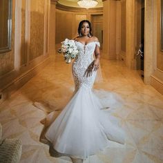 a woman in a wedding dress standing in a hallway