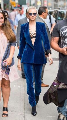 two women walking down the street wearing blue velvet outfits