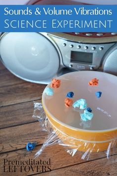 an orange bowl with blue and red candy on it sitting next to some boomboxs