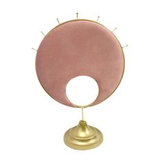 a pink and gold table lamp with spikes on it's base, against a white background