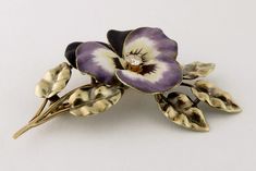 "Antique by notable Newark, NJ manufacturer A. J. Hedges 14K Yellow Gold, Enamel & Diamond Large Pansy with Leaves Brooch, c. 1910-1920 A stand-out example of enameled Pansy brooch! The flower is hand painted in the shades of burgundy-purple with exquisite realistic detailing and centering a bright and sparkling round diamond of approx. 0.15ct The pansy is presented on 14K yellow gold stem with finely wrought leaves with fantastic textural details The back is completed with original pin fitt Elegant Flower Enamel Pin Collectible, Elegant Enamel Flower Brooches, Elegant Flower Shaped Enamel Pin For Formal Occasions, Elegant Formal Flower Shaped Enamel Pin, Elegant Formal Flower Enamel Pin, Formal Flower-shaped Enamel Brooches, Formal Flower Enamel Brooches, Art Nouveau Antiques, Newark Nj