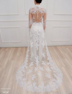 the back of a woman's wedding dress, with long sleeves and sheer lace