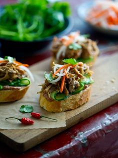 small sandwiches with meat and veggies on a cutting board