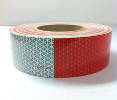 a roll of red and grey tape on a white surface