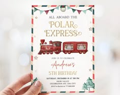 a person holding up a card with an image of a polar express train on it