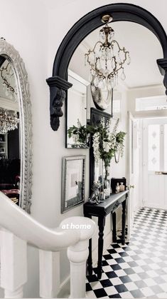 the hallway is decorated with black and white checkered flooring, chandelier and mirror