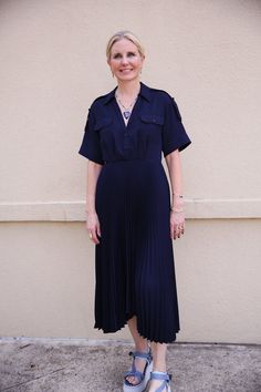 The Liam Dress features a structured yet fluid silhouette in classic navy blue. This collared midi takes inspiration from the iconic trench coat with feminine twists, from the epaulets, button-down placket, and flap chest pockets to the sharply pleated asymmetrical skirt. Composition: 100% Polyester. Ag Jeans, Pleated Midi Dress, Asymmetrical Skirt, Short Jumpsuit, Ulla Johnson, Denim Pant, Skirt Pants, Clothes For Sale, Trench Coat