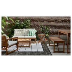 an outdoor patio with wooden furniture and brick wall