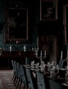 a long table with many chairs around it in a room that has paintings on the wall