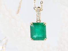 ♥ Solid 14K gold pendant set with a stunning emerald in the center, finished with a diamond-accented bail that can be opened and clipped onto a chain  ♥ The pendant measures 7.2mm in width, 8.3mm in length, and is 4.6mm thick. The bail is 6mm long and will fit with a chain up to 2.2mm thick.    ♥ Material: 14K gold  ♥ Gemstone: Emerald weighs 1.95ct, Diamonds weigh 0.03ct total    ♥ The necklace chain is *NOT INCLUDED*. You can purchase the solid 14K gold chain as an option, or use one of your existing chains for the pendant.     ▶▶ Sign up for our newsletter to receive a 10% off coupon for purchases from our website: https://www.auroradesigner.com/pages/newsletter-sign-up Classic Emerald Pendant Necklace With Diamond Accents, Luxury Diamond Cut Emerald Pendant Necklace, Luxury Emerald Cut Emerald Necklace With Diamond Accents, Luxury Emerald Rectangular Pendant Jewelry, Luxury Emerald Pendant Necklace With Diamond Accents, Rectangular Emerald Yellow Gold Jewelry, Rectangular Emerald Jewelry In Yellow Gold, Gia Certified Yellow Gold Pendant Jewelry, Timeless Green Jewelry With Diamond Accents