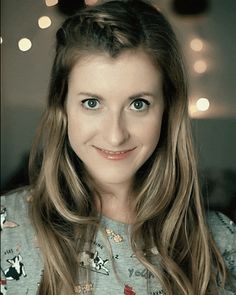 a woman with long hair and blue eyes smiles at the camera while wearing a mickey mouse shirt