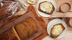 two slices of bread on plates with butter and coffee next to it, along with other food items