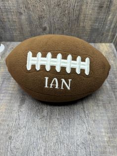 a football with the word i am written on it sitting on a wooden table next to scissors