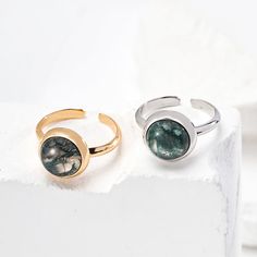 This delicate ring features stunning aquatic agate gemstones. The setting is meticulously crafted and the intricate details enhance the natural beauty of the stone, allowing its delicate hues to sparkle in the light. The adjustable strap ensures a comfortable fit, making it a versatile and elegant addition to any jewelry collection. Metal: 18K Recycled Gold Plated Vermeil on Recycled Sterling Silver,Recycled Sterling Silver Gemstone: Onyx 10mm Adjustable Ring Size: US 8 Elegant Adjustable Opal Open Ring, Adjustable Polished Moonstone Ring, Adjustable Opal Ring With Natural Stones, Polished Finish Adjustable Moonstone Ring, Adjustable Elegant Opal Ring With Polished Finish, Adjustable Gemstone Crystal Ring For Formal Occasions, Elegant Adjustable Crystal Ring With Stone Setting, Adjustable Formal Crystal Ring With Gemstone, Formal Adjustable Gemstone Crystal Ring