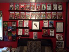 a living room filled with lots of comics on the wall and pictures hanging above it