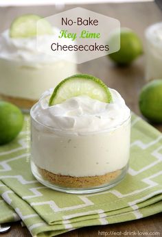 two small desserts with lime and whipped cream in them on a green napkin next to limes