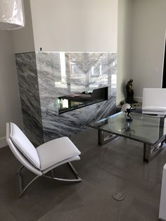 a living room filled with furniture and a glass top table in front of a wall