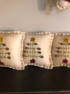 three decorative pillows are sitting on a black table next to a christmas ornament