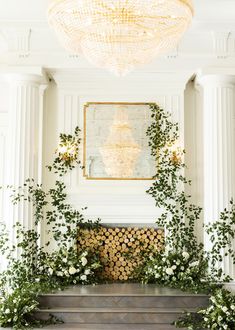 an elegant wedding ceremony with greenery and white flowers on the fireplace mantels