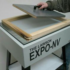 a person is working on a table with the words the lawson expo - nv