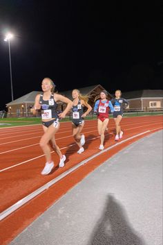 the girls are running on the track at night