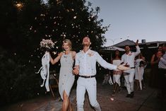 a man and woman are walking down the street with confetti in their hands