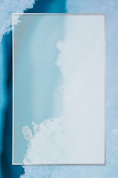 an empty square frame with blue and white water in the background, as seen from above